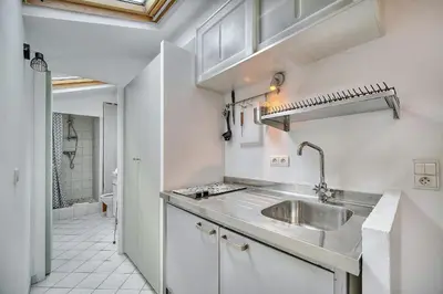 a kitchen with white cabinets and a sink at IMMOGROOM - cosy - Forville market - sea view in Cannes