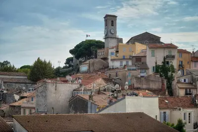 a town with a clock tower on a hill at IMMOGROOM - cosy - Forville market - sea view in Cannes