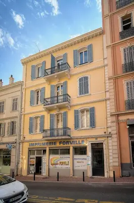 a large yellow building with balconies on a street at IMMOGROOM - cosy - Forville market - sea view in Cannes