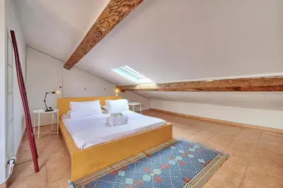a bedroom with a large bed in a attic at IMMOGROOM - cosy - Forville market - sea view in Cannes
