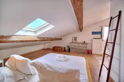 a attic room with a bed and a window at IMMOGROOM - cosy - Forville market - sea view in Cannes