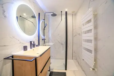 a bathroom with a sink and a shower with a mirror at Le Bain De Soleil - Le Bain De Soleil 5 star Two bedroom apartment in Cannes