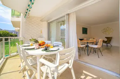 a dining room with a table and chairs on a balcony at Le Bain De Soleil - Le Bain De Soleil 5 star Two bedroom apartment in Cannes