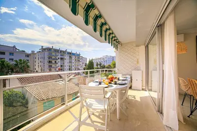 a balcony with a table and chairs on a balcony at Le Bain De Soleil - Le Bain De Soleil 5 star Two bedroom apartment in Cannes