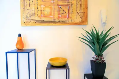 two tables with a plant and a painting on the wall at Le Bain De Soleil - Le Bain De Soleil 5 star Two bedroom apartment in Cannes