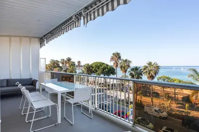 a balcony with a table and chairs and the ocean at REF 1426 - Cannes Croisette - Sea view apartment for rent in Cannes