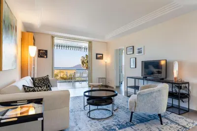 a living room with a couch and a table at REF 1426 - Cannes Croisette - Sea view apartment for rent in Cannes