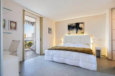 a bedroom with a large bed and a balcony at REF 1426 - Cannes Croisette - Sea view apartment for rent in Cannes