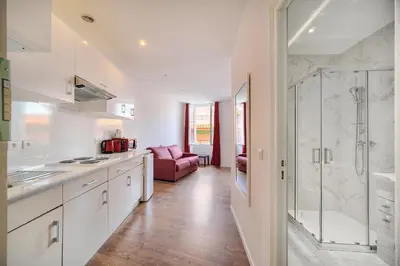 a kitchen with white cabinets and a glass shower at Charmant 2 pièces MEYNADIER-FORVILLE A1B209 in Cannes