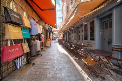 an alley with tables and chairs on a street at Charmant 2 pièces MEYNADIER-FORVILLE A1B209 in Cannes