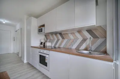 a kitchen with white cabinets and a sink at IMMOGROOM - Terrace - Near shops - Parking - Wifi - AC livingroom in Cannes