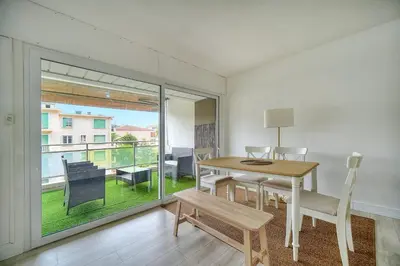 a dining room with a table and a balcony at IMMOGROOM - Terrace - Near shops - Parking - Wifi - AC livingroom in Cannes
