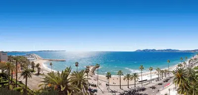 a view of a beach with palm trees and the ocean at Kiss in Cannes