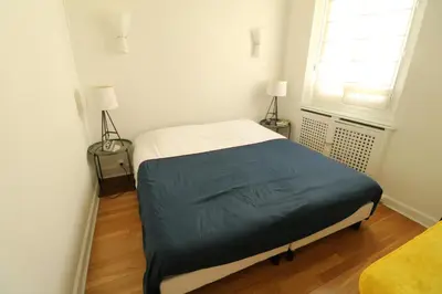 a bed in a room with two lamps and a window at 1 bedroom with direct view to the Old Port 267 in Cannes