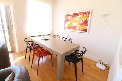 a dining room table with chairs and a painting on the wall at 1 bedroom with direct view to the Old Port 267 in Cannes