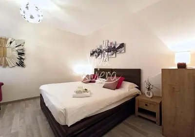 a bedroom with a bed with white sheets and pink pillows at Calm and Modern 1 Bedroom City Centre Cannes in Cannes