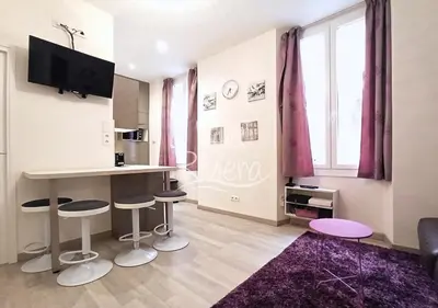 a living room with a kitchen with stools and a table at Calm and Modern 1 Bedroom City Centre Cannes in Cannes