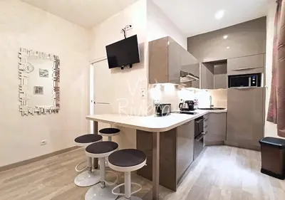 a kitchen with a counter and stools in it at Calm and Modern 1 Bedroom City Centre Cannes in Cannes