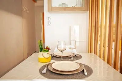 a table with two plates and wine glasses on it at Cocoon Center - Rue d'antibes - 200m plage- Clim - wifi - Unique in Cannes