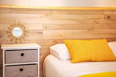 a bedroom with a bed with a yellow pillow and a mirror at Cocoon Center - Rue d'antibes - 200m plage- Clim - wifi - Unique in Cannes
