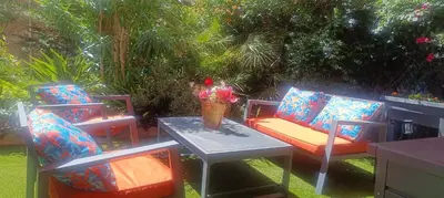 a patio with two chairs and a table with flowers on it at Résidence Chantemerle in Cannes