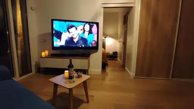 a living room with a flat screen tv and a table at Résidence Chantemerle in Cannes