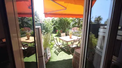 an open door to a patio with a table and an umbrella at Résidence Chantemerle in Cannes