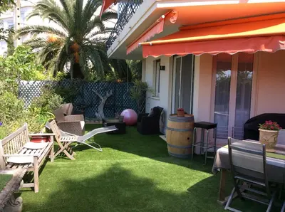 a patio with chairs and a table and a barrel at Résidence Chantemerle in Cannes