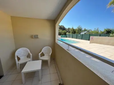 a balcony with two chairs and a table and a swimming pool at Cannes Villa Francia in Cannes