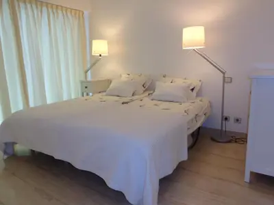 a bedroom with a large white bed with two lamps at B&B Villa Feline in Cannes