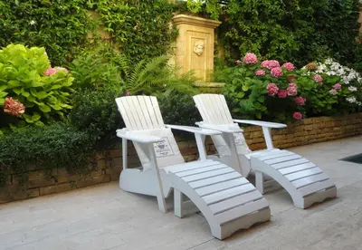 two white chairs sitting on a patio with flowers at B&B Villa Feline in Cannes