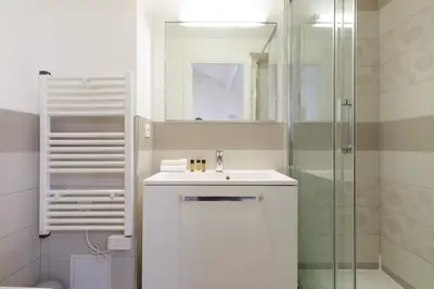 a white bathroom with a sink and a shower at Doris YourHostHelper in Cannes