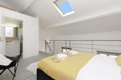 a bedroom with a large bed with a yellow blanket at Doris YourHostHelper in Cannes