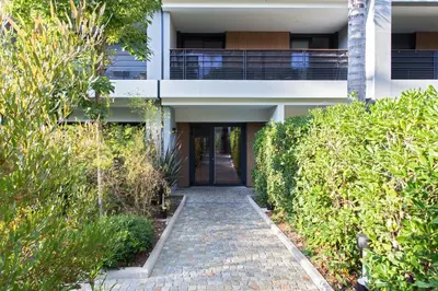 a walkway leading to a building with bushes at Appartement Maréchal - Welkeys in Cannes