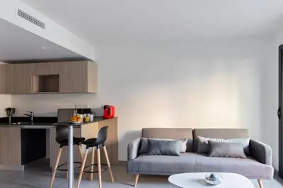 a living room with a couch and a table at Appartement Maréchal - Welkeys in Cannes