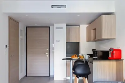 a kitchen with a door and a table with chairs at Appartement Maréchal - Welkeys in Cannes