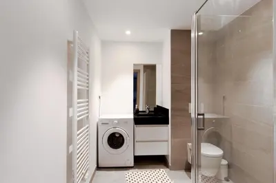 a bathroom with a washing machine and a toilet at Appartement Maréchal - Welkeys in Cannes