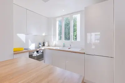 a white kitchen with white cabinets and a sink at 2Br 3 min from the center & the Croisette in Cannes
