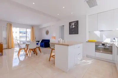 a kitchen with white cabinets and a table and chairs at 2Br 3 min from the center & the Croisette in Cannes
