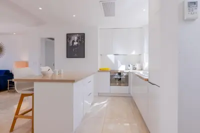 a kitchen with white cabinets and a wooden counter top at 2Br 3 min from the center & the Croisette in Cannes