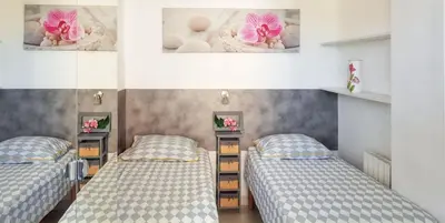 two twin beds in a room with two posters on the wall at Appartement charmant à Cannes avec vue sur la mer, 33 m² in Cannes