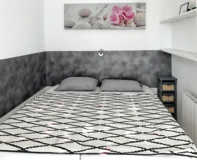 a bedroom with a bed with a black and white quilt at Appartement charmant à Cannes avec vue sur la mer, 33 m² in Cannes