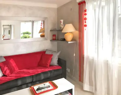 a living room with a red couch and a window at Appartement charmant à Cannes avec vue sur la mer, 33 m² in Cannes