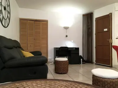 a living room with a black couch and a table at C087-Comfortable apartment in the heart of Cannes in Cannes