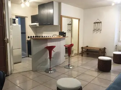 a kitchen with a counter and red stools in it at C087-Comfortable apartment in the heart of Cannes in Cannes