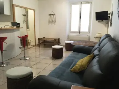a living room with a blue couch and a table at C087-Comfortable apartment in the heart of Cannes in Cannes