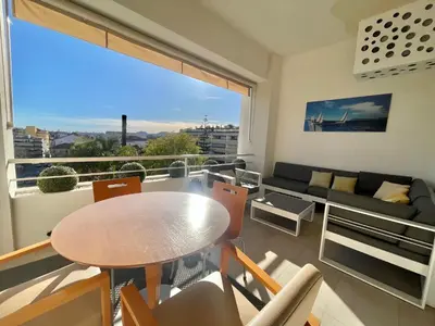 a living room with a table and a large window at Gallia Park by Welcome to Cannes in Cannes
