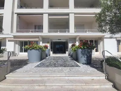 a white building with two large pots of flowers at Gallia Park by Welcome to Cannes in Cannes