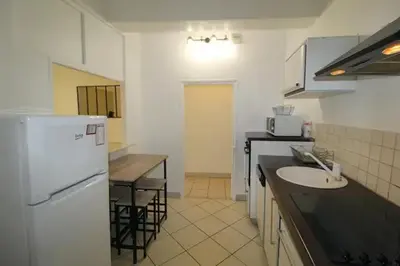 a kitchen with a white refrigerator and a sink at Appartement confortable à Cannes avec climatisation - 53 m² in Cannes
