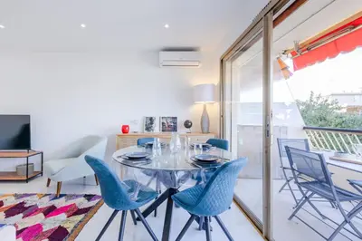 a dining room with a glass table and blue chairs at 1-Br Apartment 5 min on foot from the Croisette in Cannes